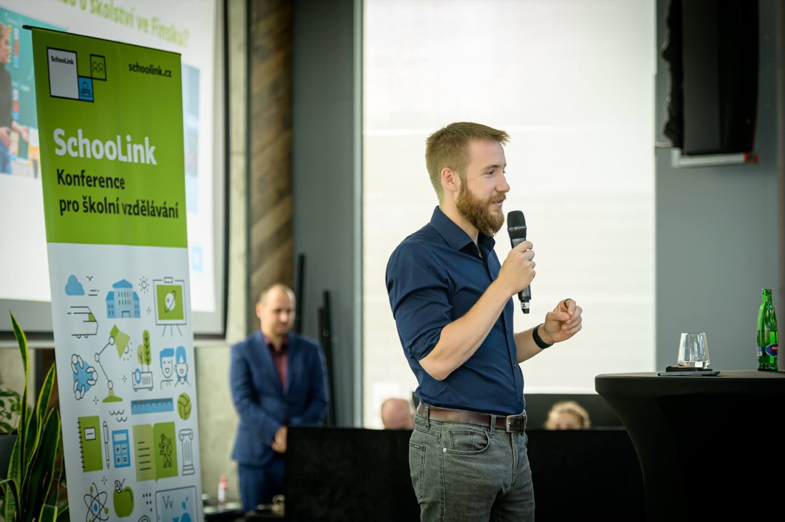 Daniel Pražák s mikrofonem na konferenci SchooLink